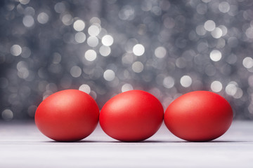 Three red Easter eggs over abstract background