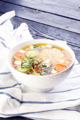 Broth with carrots, onions various fresh vegetables in a pot - c