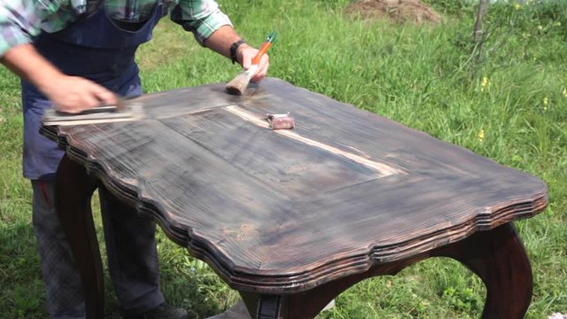 New Life of an Old Table/The cabinet maker restores the larch table. He polishes the wood carefully to put any roughness. Sound on