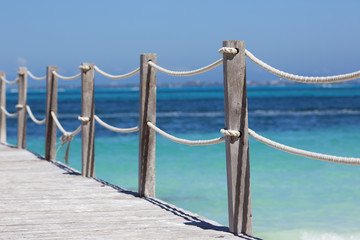 Wooden bridge over the turquoise water of the Caribbean sea.