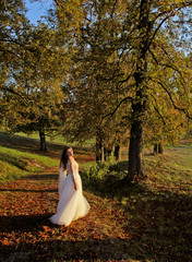 Bride dance at the sunset in autumn. Beauty sunlight, orange leaves and trees in happy wedding day