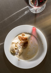 Wine glass leaves shadow across finished dinner plate
