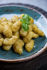 Italian traditional potato gnocchi with basil pesto, close-up, shallow depth of field