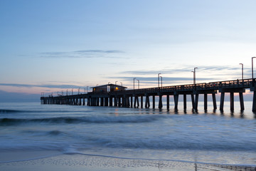 Obraz premium fishing Pier at Dusk with Beach Foam