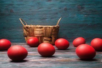 Easter concept with empty basket and red eggs