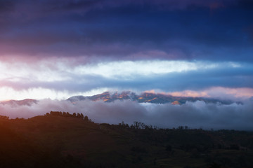 Volcano of Irazu partially hidden in clouds during sunset. Costa Rica