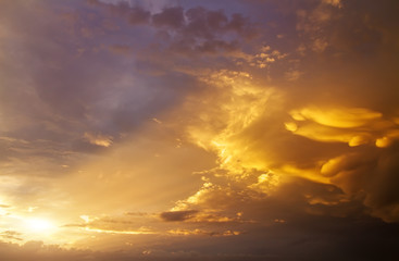 Beautiful dark fluffy cloudy sky with sun rays. Sunset light.