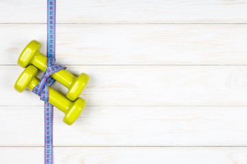 Dieting and fitness concept plan on white wood background.