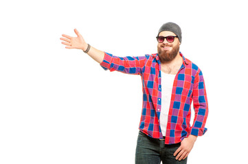 Naklejka premium Here can be your advertising. Portrait of smiling young bearded man in sunglasses pointing away while standing against white background