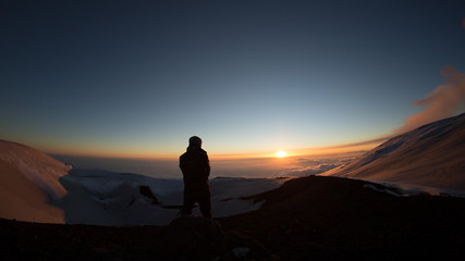 Silhouette escursionista che guarda il tramonto in controluce sul vulcano Etna-Sicilia