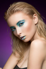 Naklejka premium Hot and cold. Vertical cropped shot of a blonde fashion model wearing futuristic blue shaded makeup with metallic lips looking to the camera fiercely