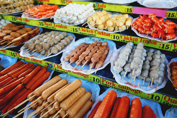 Grilled Thai sausages, fishballs and seafood on the stove at Traditional Market, Thailand
