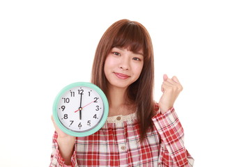 時計を持つパジャマ姿の女性
