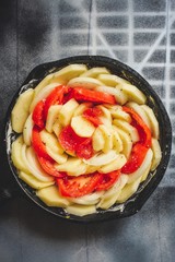 Gratin with potatoes and tomatoes (vegetable casserole) in a cast-iron frying pan