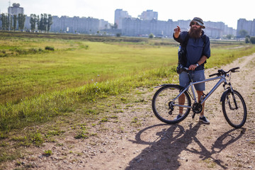 hipster man on a bicycle in the countryside
