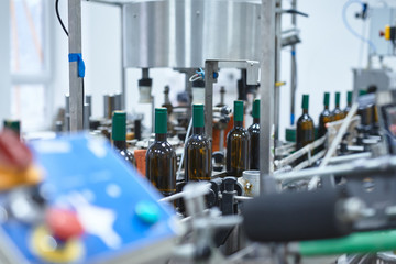 Row of glass wine bottles moving by conveyor