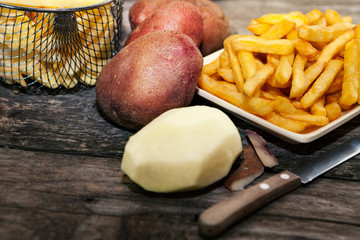 Peeled potato with french fries in the background
