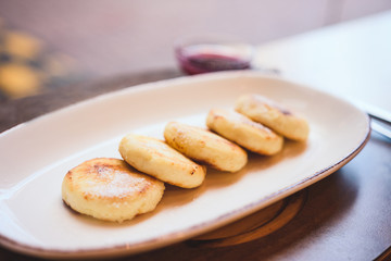 Cheese pancakes on white plate at restaurant. Selective focus. Top view