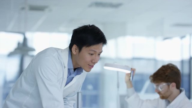  Electronics engineers working in the lab with manager overseeing