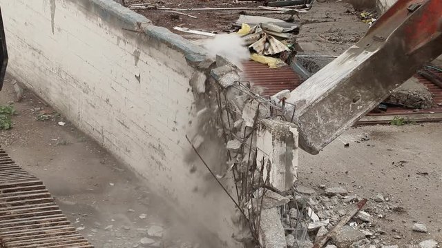 Wall demolition on construction site by bulldozer