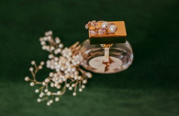 The luxury earrings stands on the perfume