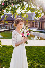 The charming bride keeps a weding bouquet