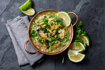 Seafood ceviche or mariscal in copper bowl - traditional Latin American dish with seafood, onion...