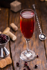 A glass of sparkling wine with liqueur and blackcurrant