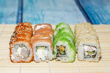 Fresh sushi with red and green caviar and salmon on a wooden blue table