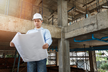Engineer with blueprint in building construction site