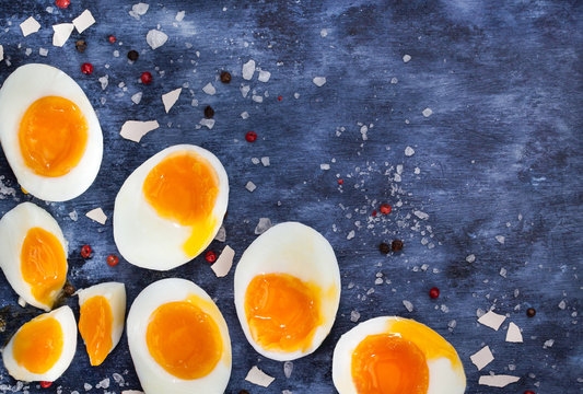 Hard boiled eggs, sliced in halves on wooden table