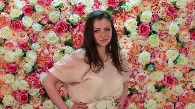 Portrait of young sexy woman in pink dress, background of bright floral wall