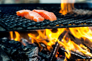 Grilled salmon steaks on a grill. Fire flame grill. Restaurant and garden kitchen. Garden party.
Healthy dish.