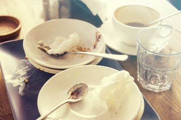 Dirty plates spoonful fork crumpled napkins on table in cafe