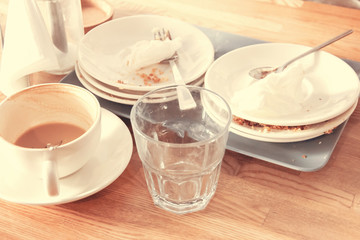 Fototapeta na wymiar Cup unfinished cappuccino empty glass crumpled napkins spoonful fork after meal