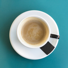Cup of coffee on turquoise with copyspace