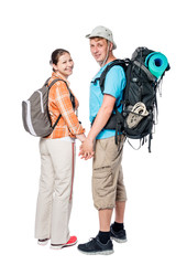 Happy couple with backpacks holding hands in studio on white background
