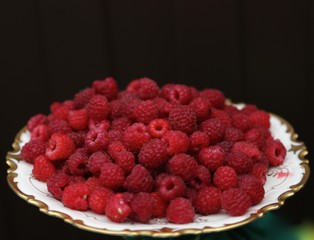 red  fresh  ruspberry  on  the  plate in  summer  in  the  village 