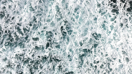 Aerial view of the foam, spray and turquoise sea water..View from above of the ocean.