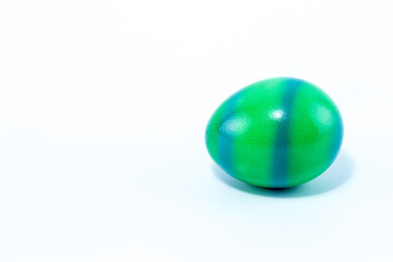 Easter egg hand painted in home - green with blue stripes, isolated in white background