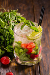 Cocktail with tequila, peach liqueur, soda, with a lime and mint