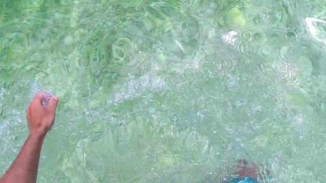 Man wades into the sea while on a beach vacation and dips to have a swim