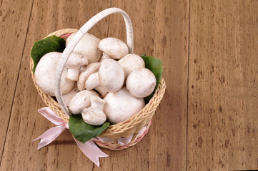 Basket with fresh champions on an old wooden background