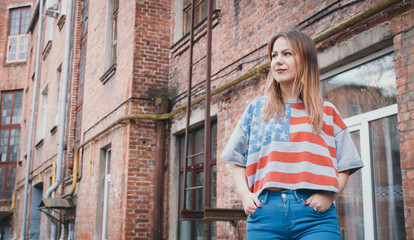 A hipster girl in an old courtyard posing and smiling