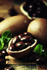 Easter composition with chocolate eggs, vintage wooden background, rustic style, selective focus