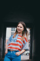 A hipster girl in an old courtyard posing and smiling