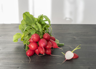 Bunch of fresh red radishes on a wooden table in the kitchen
