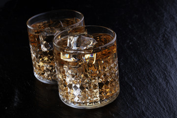 glass of whiskey with ice on a wooden