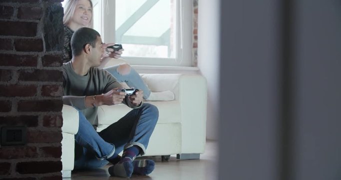 multiethnic group of friends people enjoy relaxing on couch playing videogames and having fun indoor in modern industrial house. 4k handheld video shot