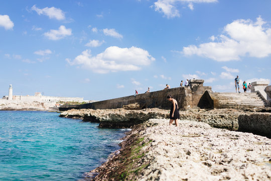20 something walks along the ocean on the Malecon in Old Havana, Havana Cuba